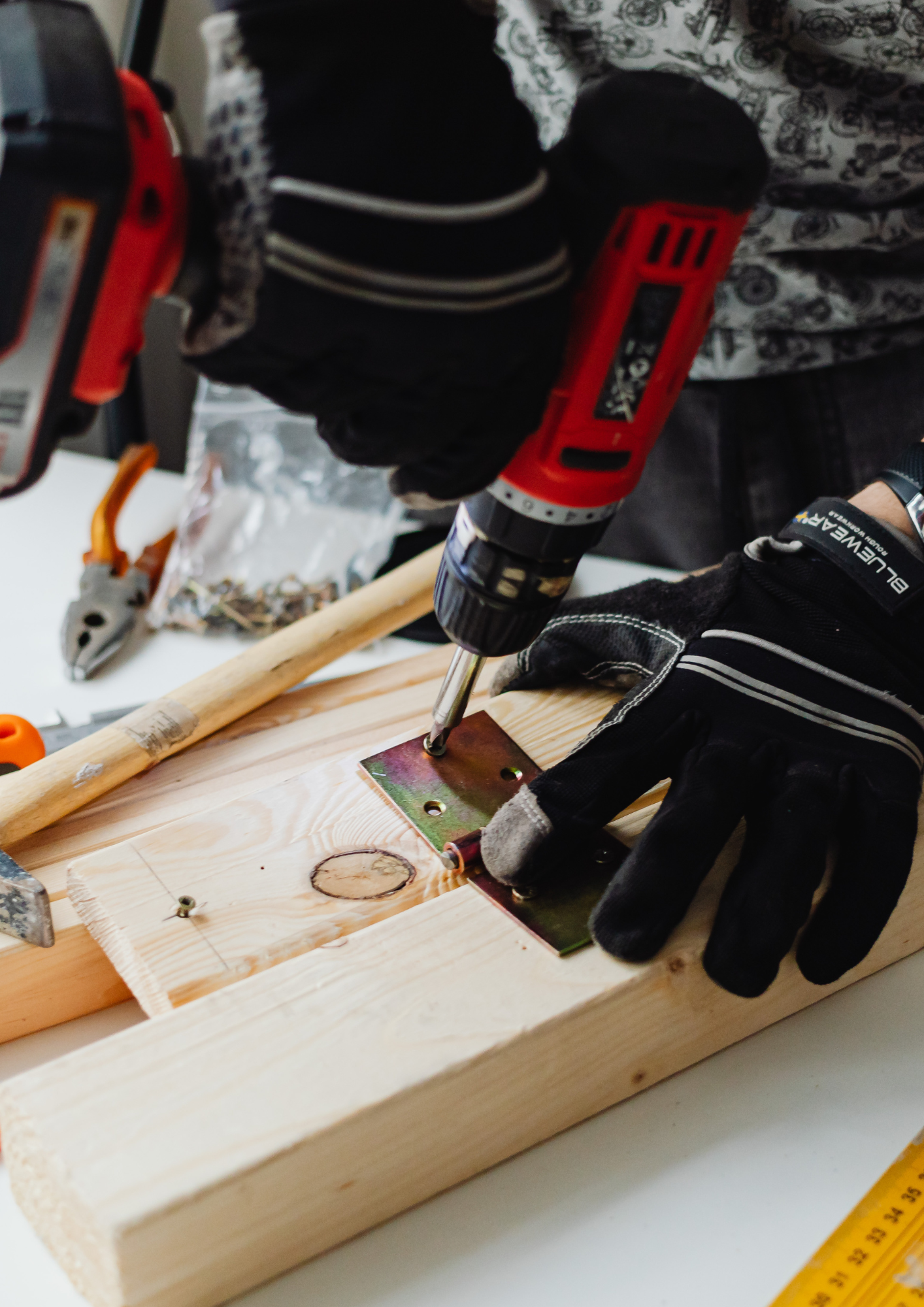 Handyman drilling a metal bracket onto a wood frame